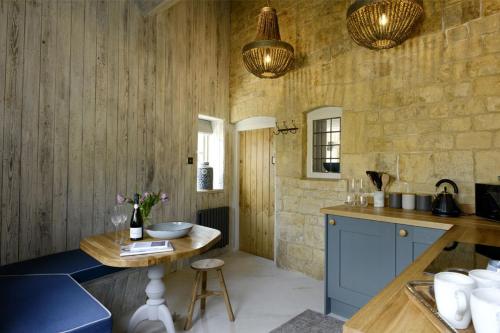 莫顿因马什沃尔纳特度假屋的厨房配有蓝色橱柜和木墙