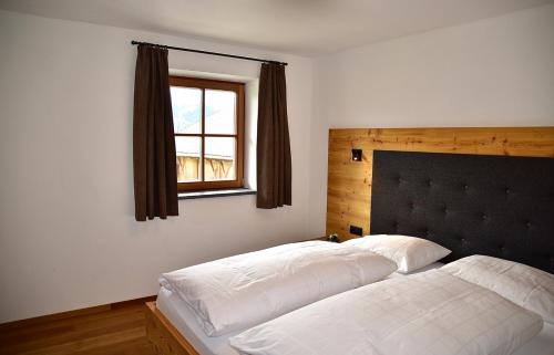 富内斯普册霍夫公寓式酒店的一间卧室设有两张白色的床和窗户