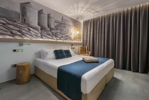 罗德镇埃拉卡蒂豪华精品情趣酒店的卧室配有一张大床,墙上挂有绘画作品