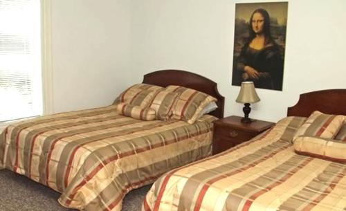 沃萨加比奇海滩Inn On The Beach的一间卧室设有两张床,墙上挂着一幅画