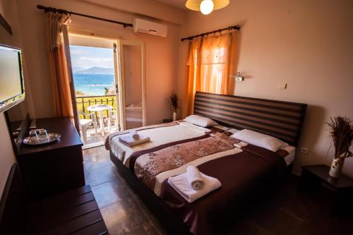 爱琴娜岛乌尔丽卡酒店的一间卧室设有一张大床和一个大窗户
