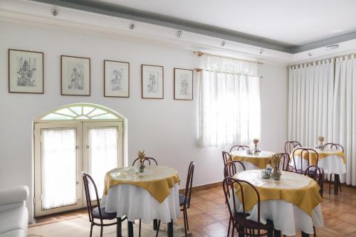 坎皮纳斯卡萨布兰卡酒店的一间用餐室,配有两张带黄桌布的桌子
