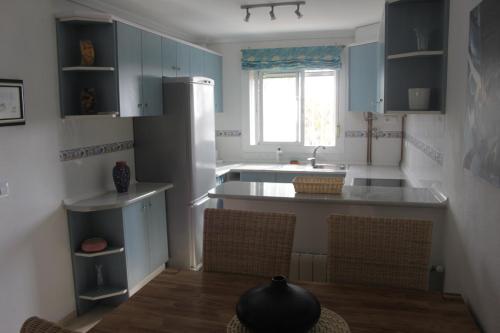 格兰阿利坎特Appartement 179的一间厨房,内配蓝色橱柜和厨房岛