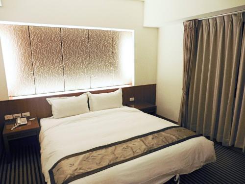 东港大鹏湾度假酒店的酒店客房设有床和窗户。
