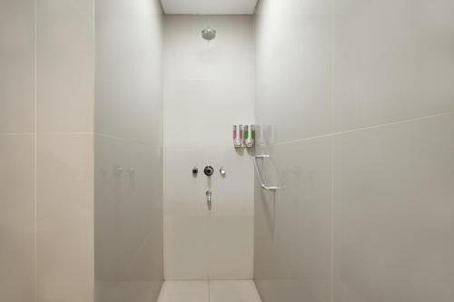 泗水爱玛瑞丝泗水马格雷酒店的浴室里设有玻璃门淋浴