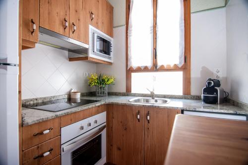 Bellmunt de CiuranaColonia Apartamento Rural的一个带木制橱柜和水槽的厨房