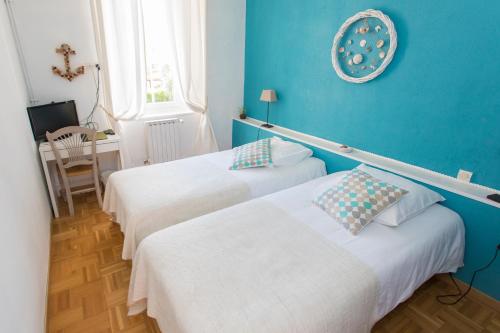勒博塞库奇叶酒店的蓝色墙壁客房的两张床