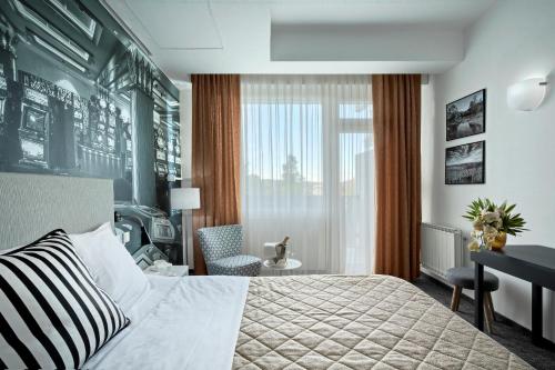 新戈里察Park, Hotel & Entertainment的配有一张床、一张书桌和一扇窗户的酒店客房