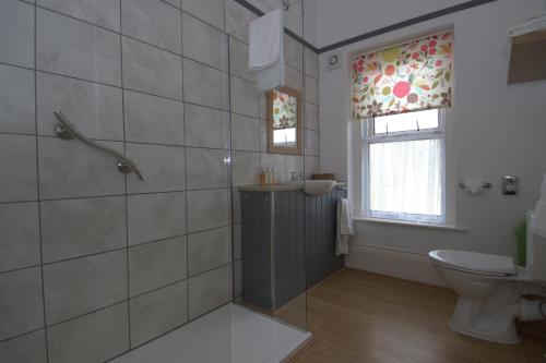 尚克林韦斯特伯里旅舍的带淋浴和卫生间的浴室以及窗户。