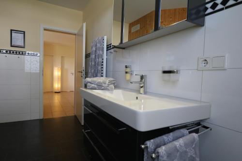 格赫伦-莱宾Villa Harmonie W1的浴室设有白色水槽和镜子