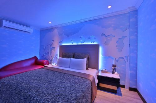 树林区月圆汽车旅馆的一间卧室配有一张大床和紫色墙壁