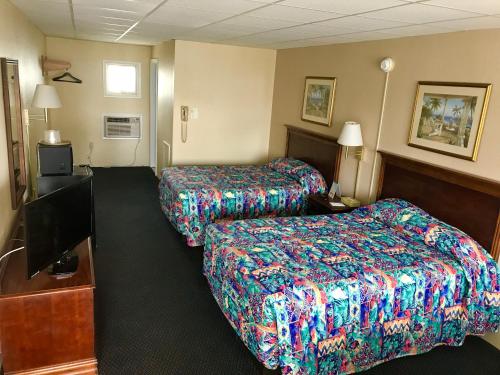 大洋城Tides Inn的酒店客房设有两张床和一台平面电视。