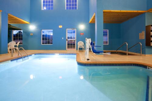 拉皮德城GrandStay Residential Suites Rapid City的蓝色墙壁的房间中的一个大型游泳池