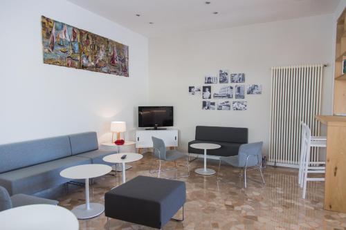 卡萨尔博瑟蒂Hotel Turismo Europa的客厅配有沙发、桌子和电视