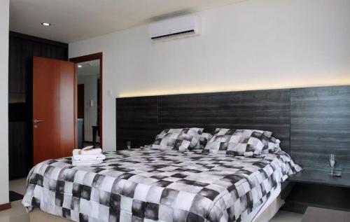 雅加达绿湾凯文公寓的卧室配有黑白格子床