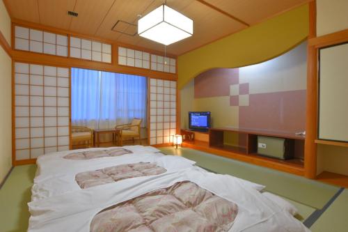 伊贺市伊贺日光希尔酒店的一间卧室配有一张床和一台电视。