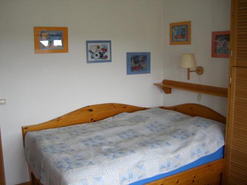 内贝尔Gästehaus Kapitän Jan Ricklefs的一间卧室配有一张带蓝色棉被的木床