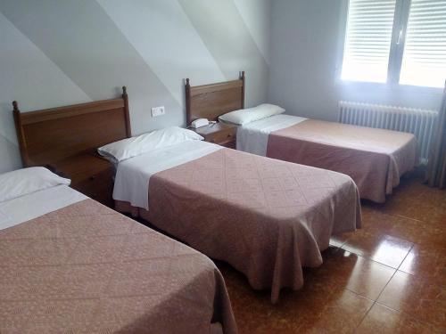 托梅略索欧罗巴酒店的酒店客房设有三张床和窗户。