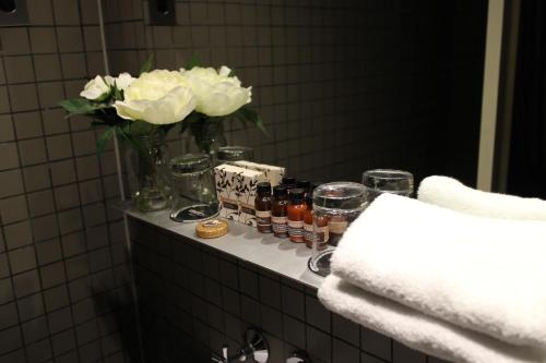悉尼悉尼凯克登酒店的浴室柜台,配有白色花瓶和罐子