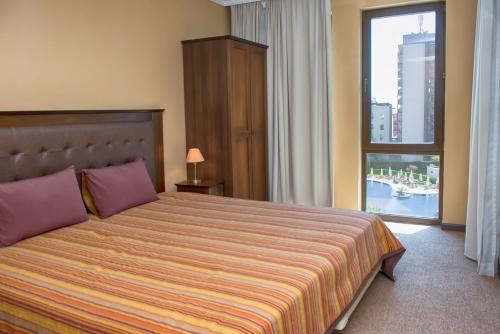 阳光海滩皇家海滩公寓 的一间卧室设有一张大床和大窗户