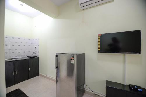 科尔瓦Sunshine Park Homes的客房设有冰箱和壁挂式平面电视。
