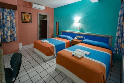 卡门城Hotel Acuario的酒店客房,配有两张床和椅子