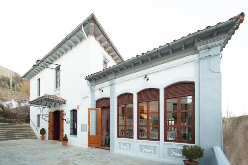 贝纳萨尔La Castellana - Habitaciones y desayuno的白色的建筑,设有棕色的门窗