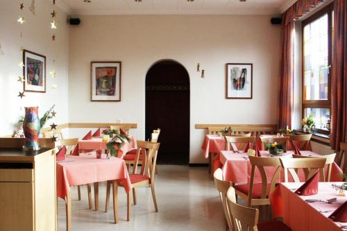 汉诺威奥特奥赛尔斯酒店的餐厅配有桌椅和红色桌布