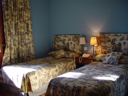 Sardón de DueroLa Puerta de la Ribera的一间卧室配有两张床、一盏灯和一部电话