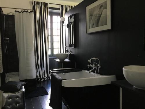 BoucéLe Domaine de Cordey的黑色浴室设有浴缸和水槽