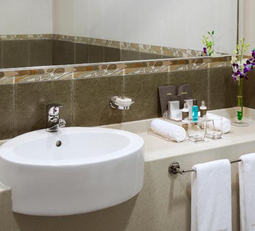 迪拜TIME橡木酒店及套房的浴室设有白色水槽和镜子