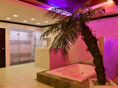 台中市心圆精致汽车旅馆的棕榈树,浴室内有粉红色的墙壁