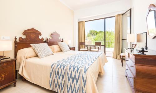 帕格拉伽雅酒店的一间卧室配有一张床、梳妆台和电视。