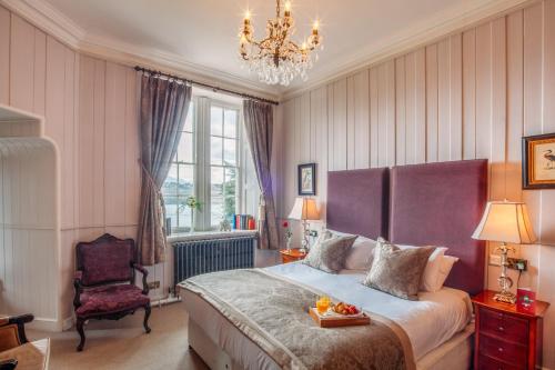 梅奈布里奇瑞安法城堡酒店的一间卧室配有一张床,上面有水果盘