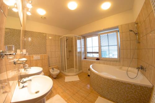 普日博尔Wellness Hotel Hukvaldy POLOPENZE A WELLNESS V CENĚ的带浴缸、盥洗盆和卫生间的浴室