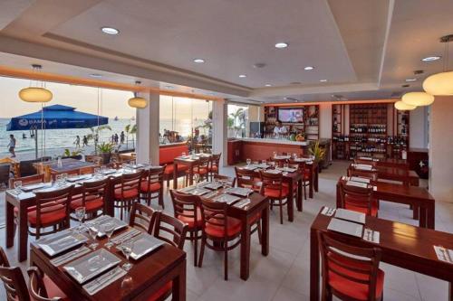 长滩岛长滩岛海滨时光酒店的一间设有木桌和椅子的餐厅,享有海景