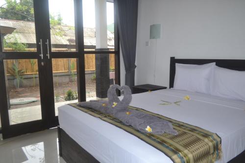 吉利特拉旺安Akalanka Homestay的一间卧室设有一张大床和大窗户