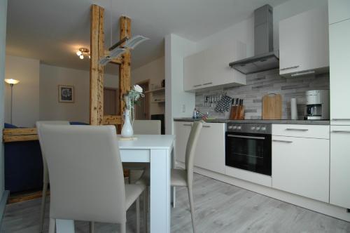 奥伯霍夫Extrablatt的厨房配有白色橱柜和桌椅