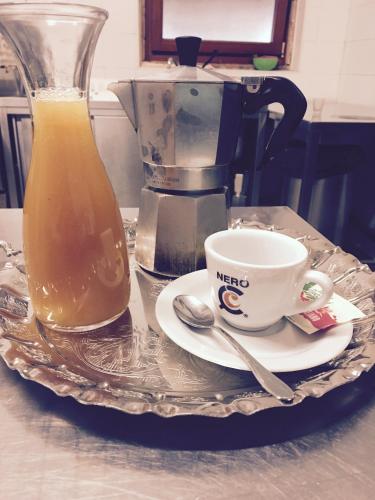 CollebrincioniUn Passo Dal Cielo的盘子,盘子上装有咖啡杯和一壶果汁