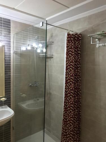 卡博尼格洛Appartement Bellavista - Cabo Negro的一间带玻璃淋浴和水槽的浴室