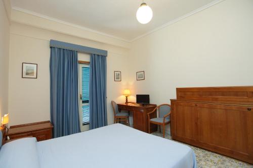 维克艾库塞美嘉马雷酒店的一间卧室配有一张床、梳妆台和书桌