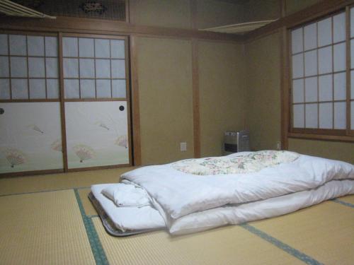 水上町仁田屋日式旅馆的一张大床,位于带两个窗户的房间