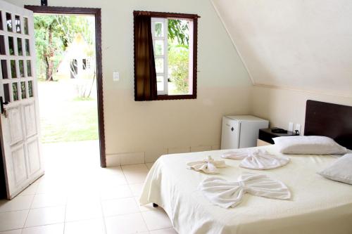 康塞桑-杜马图登特鲁Pousada do Lago Ltda的一间卧室配有一张带白色床单的床和一扇窗户。