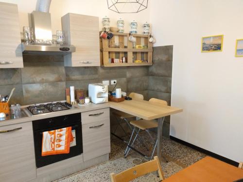 热那亚B&B Al Fronte del Porto的厨房配有桌子和炉灶。 顶部烤箱