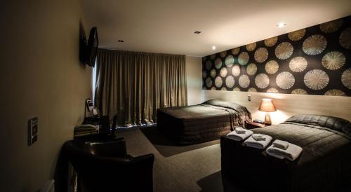 基督城Racecourse Hotel and Motor Lodge的酒店客房,设有两张床和一张沙发