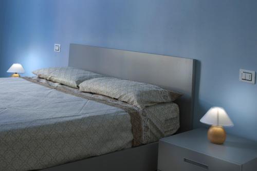 韦尔巴尼亚Residenza Intra Lago Maggiore的蓝色房间的一个床位,配有两盏灯