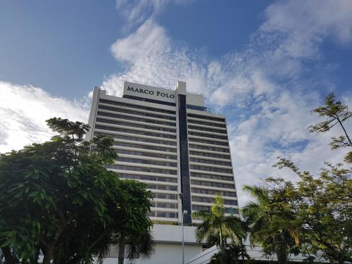 宿务Marco Polo Plaza Cebu的一座大建筑,上面有 ⁇ 的集线标志