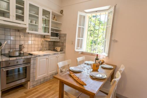 滨海拉塞讷Grand Balaguier的厨房配有木桌、椅子和窗户