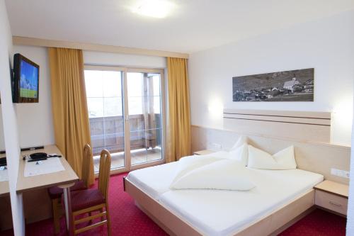 费斯Haus Mühlbach的配有一张床、一张书桌和一扇窗户的酒店客房