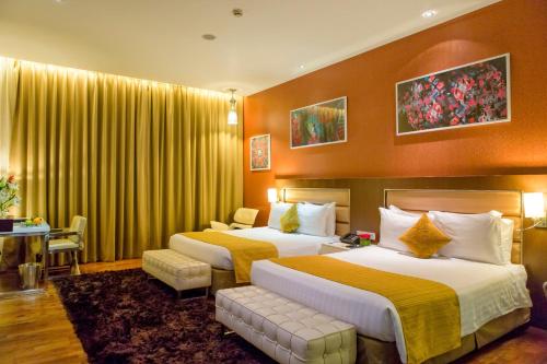 达曼德尔庭酒店的配有黄色窗帘的酒店客房的两张床